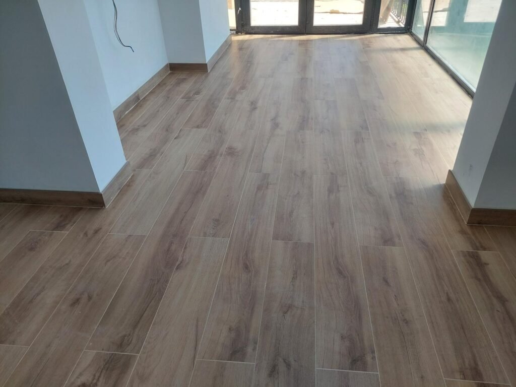 Detalle de pavimento cerámico imitación madera instalado en reforma interior