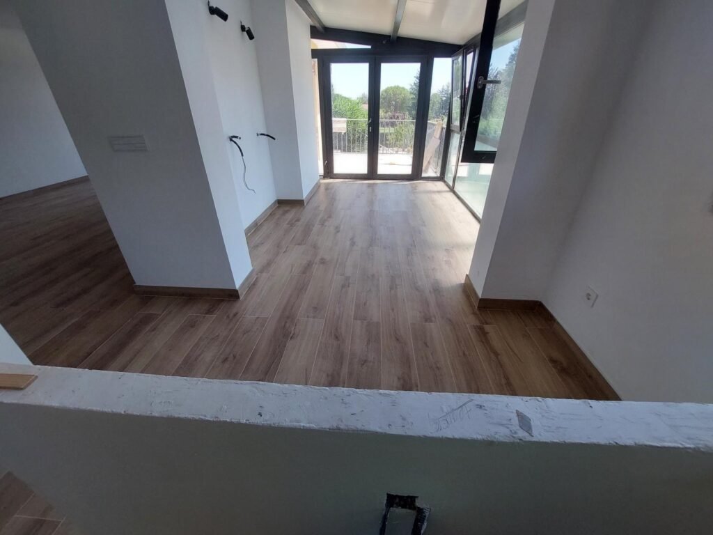 Reforma interior de vivienda con nuevo suelo cerámico imitación madera