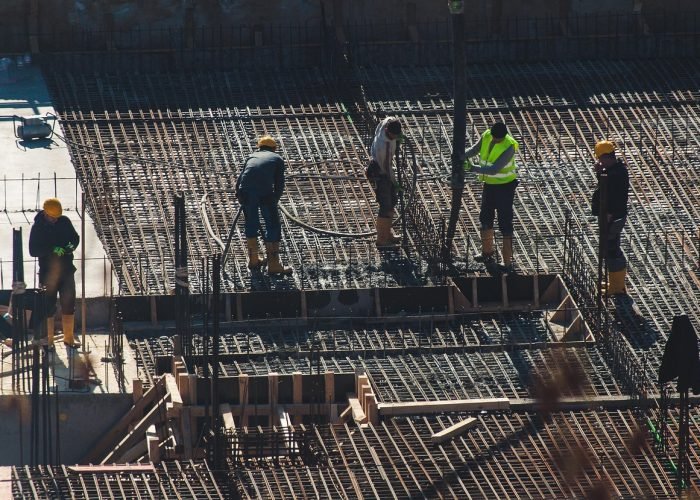 Equipo de construcción trabajando en estructura de obra nueva con coordinación técnica y supervisión profesional